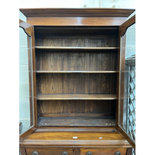 4 - An Edwardian carved mahogany bookcase with two upper glazed doors, two drawers and two cupboard door... 