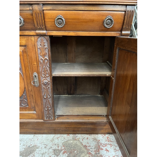 4 - An Edwardian carved mahogany bookcase with two upper glazed doors, two drawers and two cupboard door... 