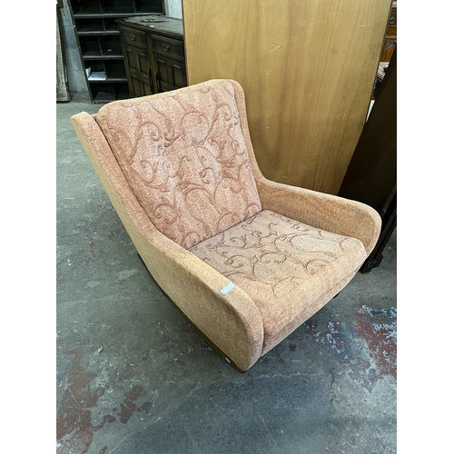 41 - A mid 20th century fabric upholstered and teak rocking armchair