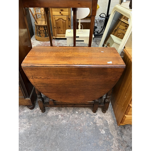 65 - An oak drop leaf gate leg oval dining table