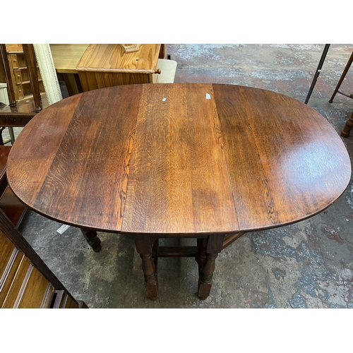 65 - An oak drop leaf gate leg oval dining table