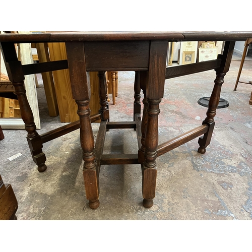 65 - An oak drop leaf gate leg oval dining table