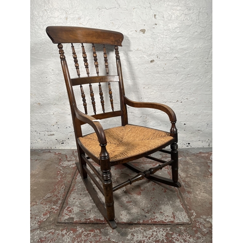 76 - A 19th century beech and rush seated spindle back farmhouse rocking chair