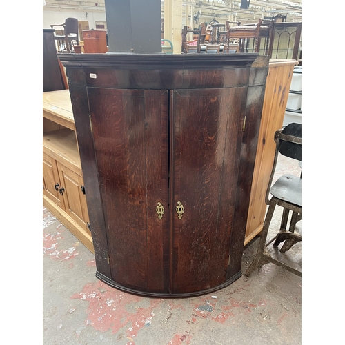 85 - A Georgian oak and mahogany crossbanded bow fronted wall mountable corner cabinet - approx. 104cm hi... 