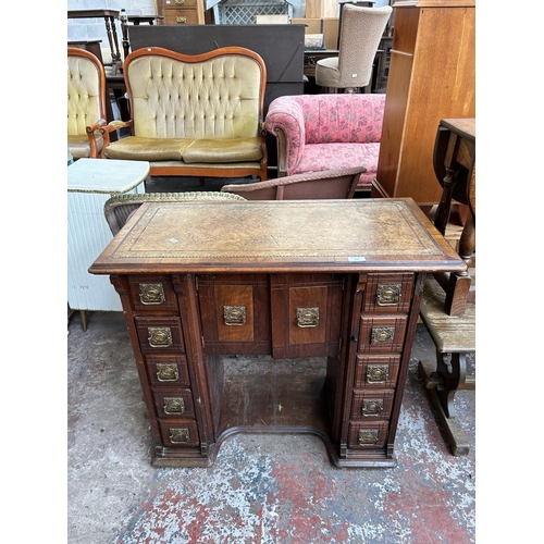 119 - A late 19th/early 20th century mahogany and walnut kneehole desk with tan leather writing surface