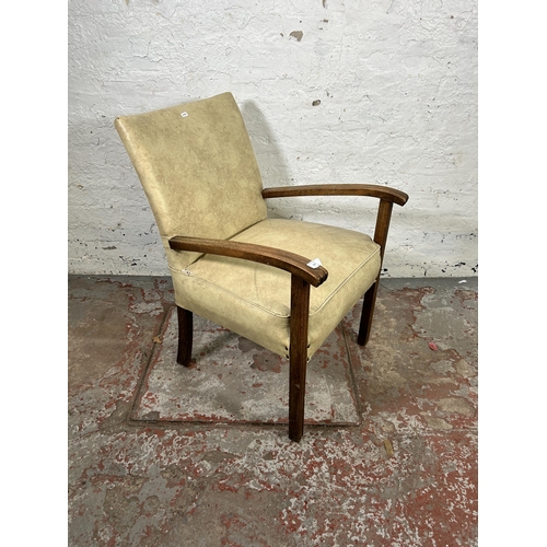 121 - A mid 20th century cream vinyl and beech armchair