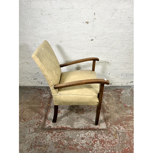 121 - A mid 20th century cream vinyl and beech armchair