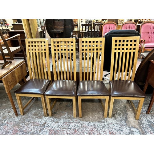 129 - A set of four modern oak and brown leatherette dining chairs