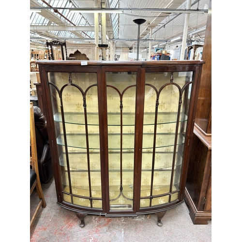 134 - An early 20th century mahogany display cabinet with two glazed doors and cabriole supports