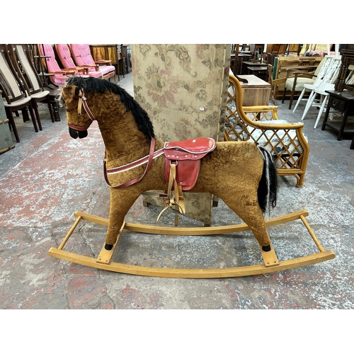 149 - A brown fabric rocking horse on beech stand