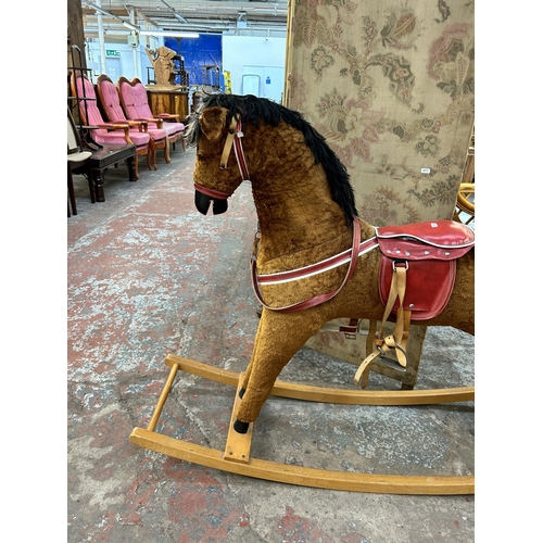 149 - A brown fabric rocking horse on beech stand