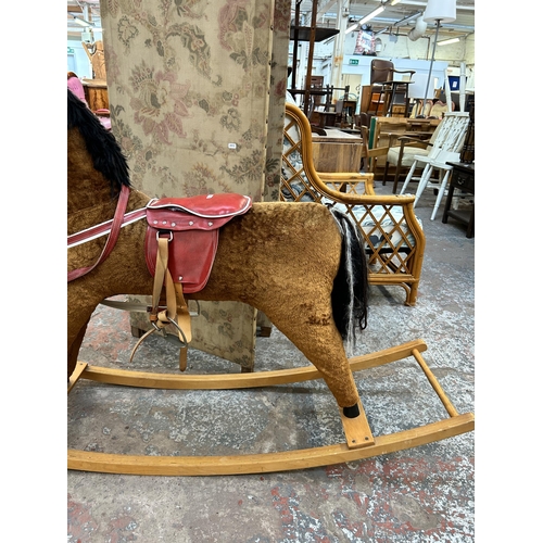 149 - A brown fabric rocking horse on beech stand