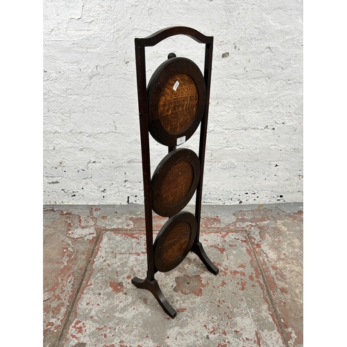 155 - An early 20th century oak three tier folding cake stand