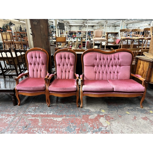 157 - A French style beech and pink fabric upholstered three piece lounge suite comprising two seater sofa... 