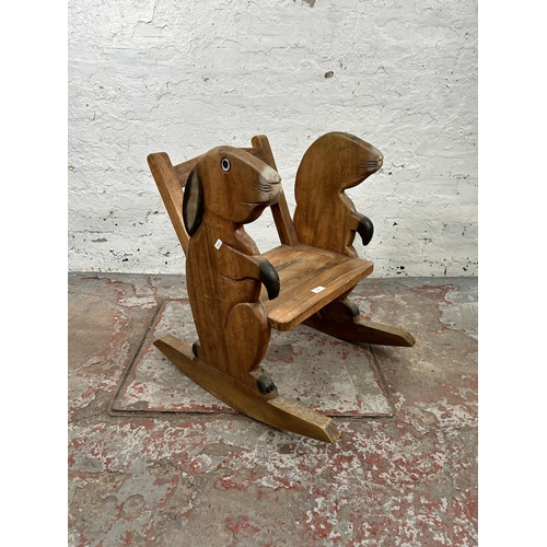 158 - A carved hardwood child's rocking chair with rabbit design