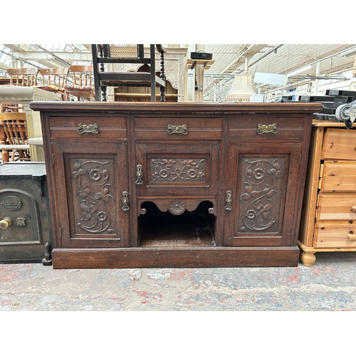 163 - An Edwardian carved mahogany sideboard with three drawers and three cupboard doors