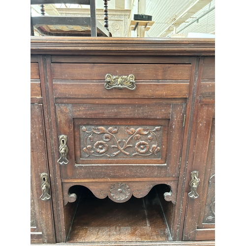 163 - An Edwardian carved mahogany sideboard with three drawers and three cupboard doors