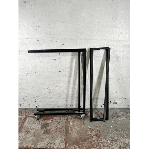 164 - A black metal sofa stand on castors