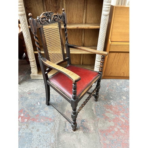 170 - An early 20th century carved oak armchair with rattan back and red leatherette upholstery