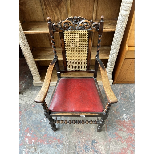 170 - An early 20th century carved oak armchair with rattan back and red leatherette upholstery