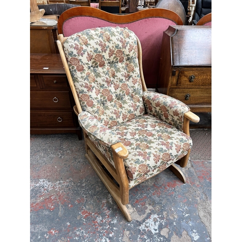 174 - A beech and tapestry upholstered rocking armchair