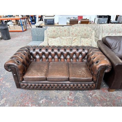 211 - A brown leather Chesterfield three seater sofa