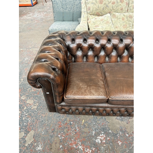 211 - A brown leather Chesterfield three seater sofa