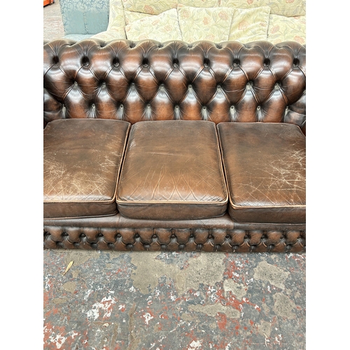 211 - A brown leather Chesterfield three seater sofa