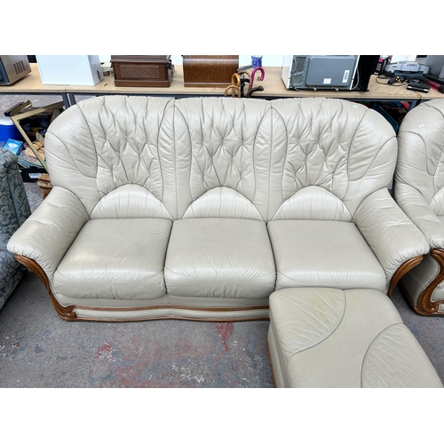 212B - A cream leather three piece lounge suite comprising three seater sofa, armchair and footstool