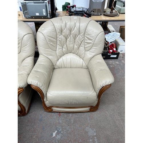 212B - A cream leather three piece lounge suite comprising three seater sofa, armchair and footstool