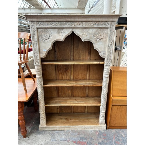 187 - A Desert Designs carved hardwood four tier free standing bookcase