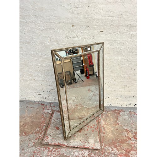 213 - A modern framed bevelled edge wall mirror - approx. 82cm high x 113 cm wide