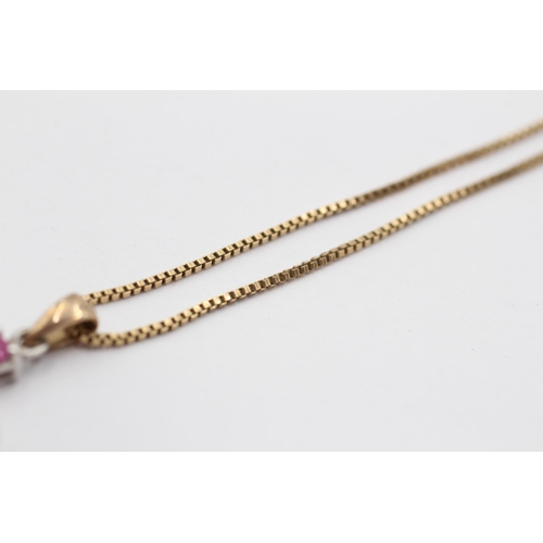 2032 - A 9ct white and yellow gold diamond and ruby cross pendant on chain - approx. gross weight 3.5g