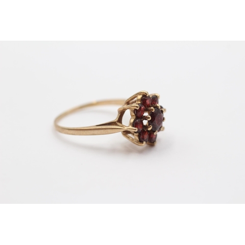 2053 - A 9ct gold garnet floral halo ring - approx. gross weight 3.1g