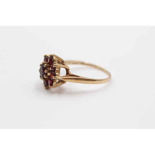 2053 - A 9ct gold garnet floral halo ring - approx. gross weight 3.1g