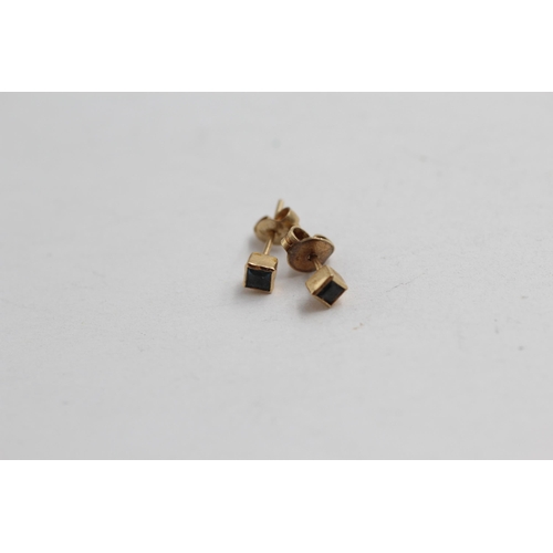 2099 - Two pairs of 9ct gold gemstone stud earrings, one topaz and one sapphire - approx. gross weight 1.3g