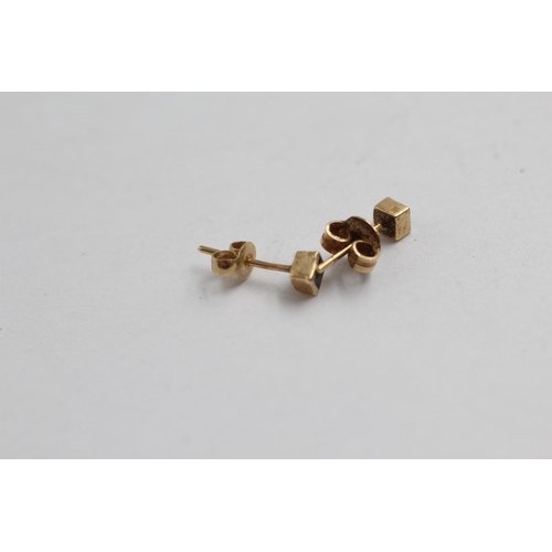 2099 - Two pairs of 9ct gold gemstone stud earrings, one topaz and one sapphire - approx. gross weight 1.3g