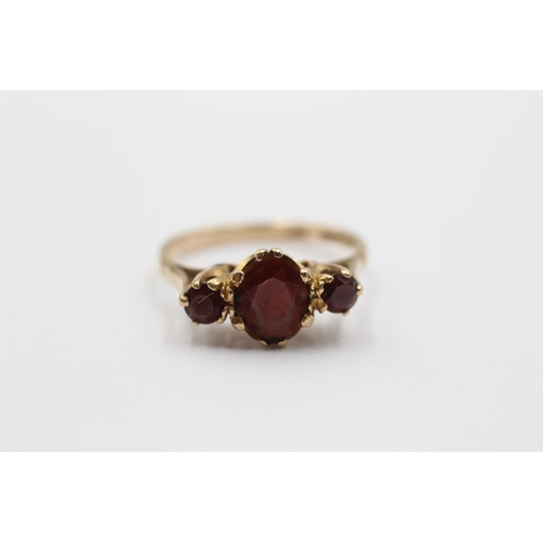 2138 - A 9ct gold garnet trilogy dress ring - approx. gross weight 1.9g