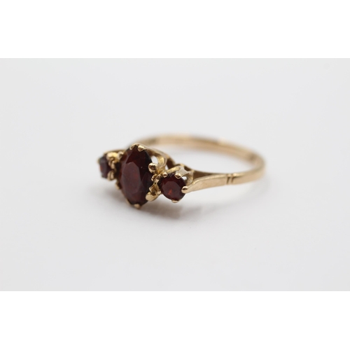 2138 - A 9ct gold garnet trilogy dress ring - approx. gross weight 1.9g