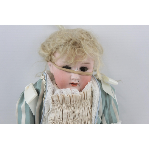 367 - An antique Heubach Koppelsdorf bisque head doll with additional clothes - no. 250-3