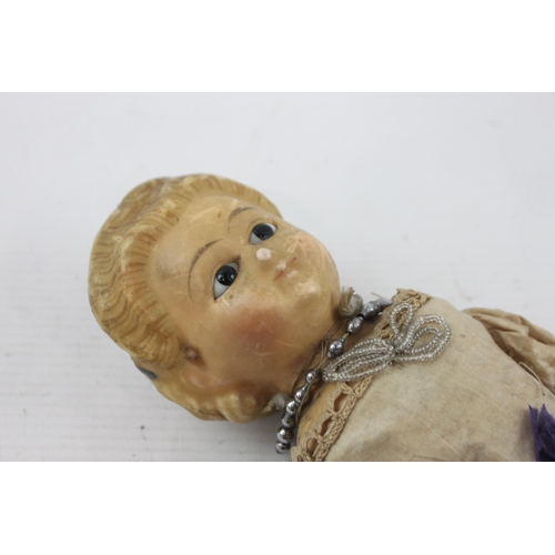 371 - A vintage doll with wooden limbs, wax on composite head and glass eyes