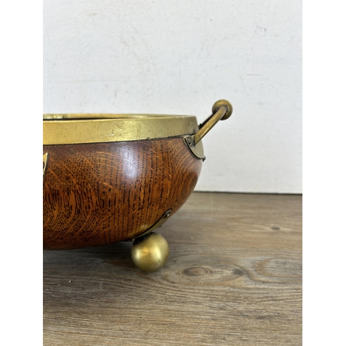 463 - An early 20th century oak and EPNS tri-footed twin handled circular bowl - approx. 23cm diameter