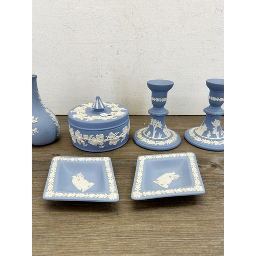 269 - Six pieces of Wedgwood pale blue Jasperware to include two candlesticks - approx. 12.5cm high etc.