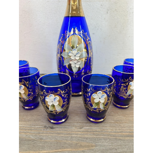 308 - A Murano cobalt blue glass seven piece drinking set with gilt and floral decoration