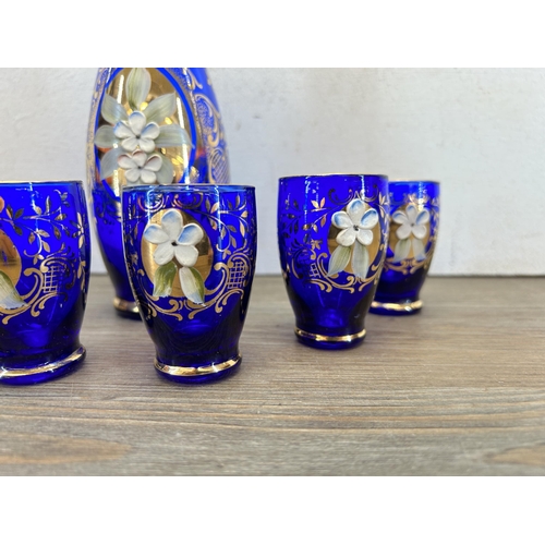 308 - A Murano cobalt blue glass seven piece drinking set with gilt and floral decoration