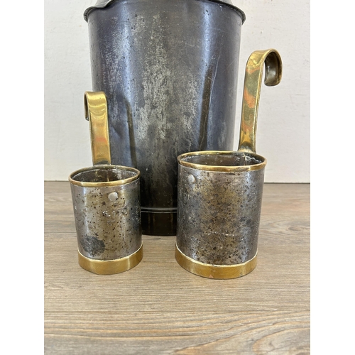 330 - A black metal and brass 2.5 gallon canister with one pint and one half pint measuring jugs - caniste... 