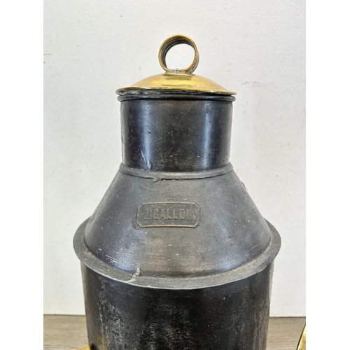 330 - A black metal and brass 2.5 gallon canister with one pint and one half pint measuring jugs - caniste... 