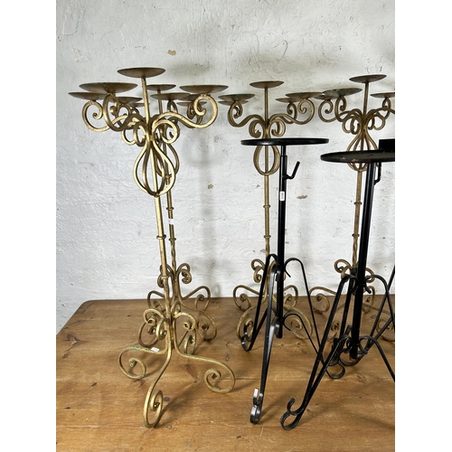 335 - Nine 19th century style wrought metal candelabras and plant stands - largest approx. 91cm high