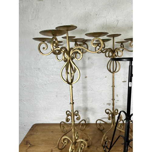 335 - Nine 19th century style wrought metal candelabras and plant stands - largest approx. 91cm high