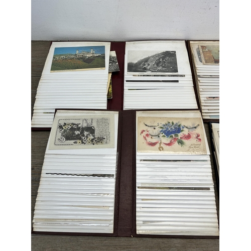 396 - Four albums containing a large collection of antique and vintage postcards to include silk, birthday... 